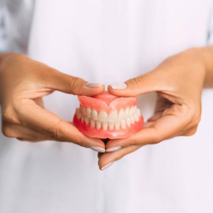 Lady presents viewer with dentures