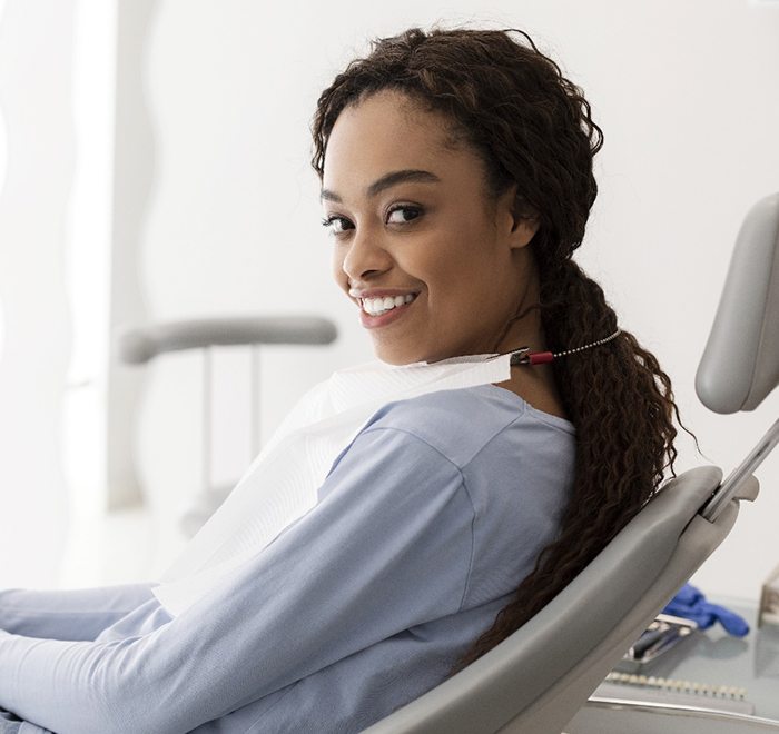 A young female sitting patiently in the dentist’s chair preparing for laser dentistry in Long Beach