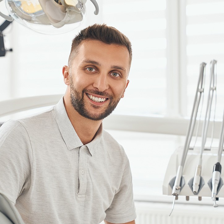 Man sitting forward in chair smiling
