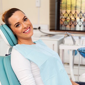 Woman leaning back in dental chair smiling
