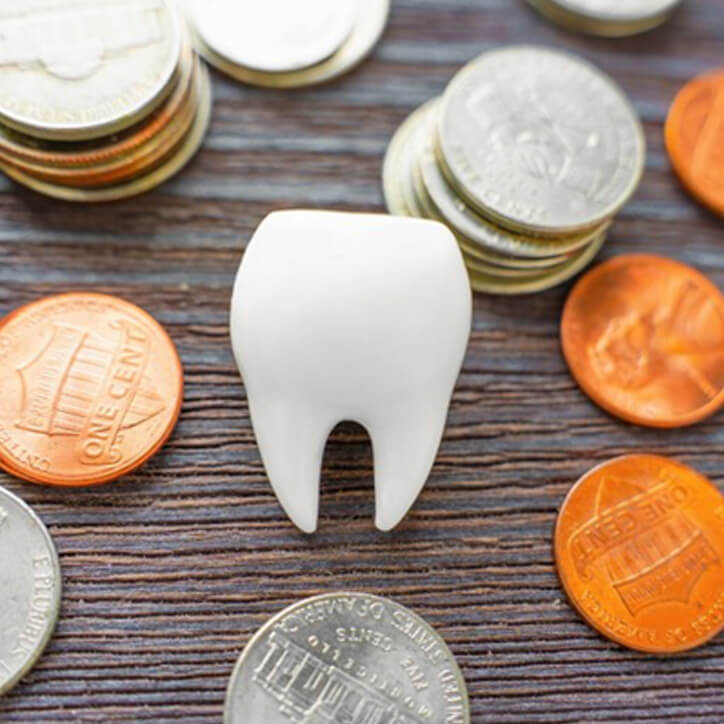 A tooth on a table surrounded by coins
