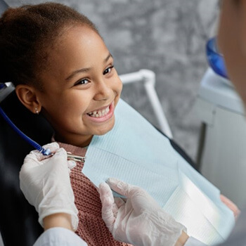 A child patient smiling at her dentist