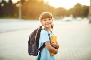 Little girl looking back and smiling before heading to school